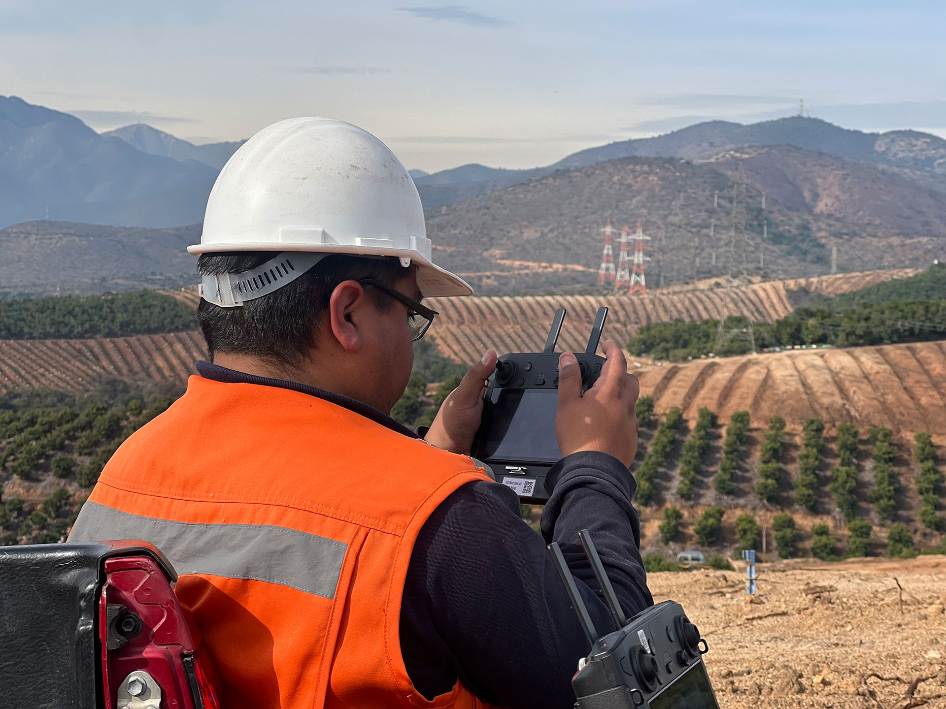 Drone operator capturing images of electrical transmission lines